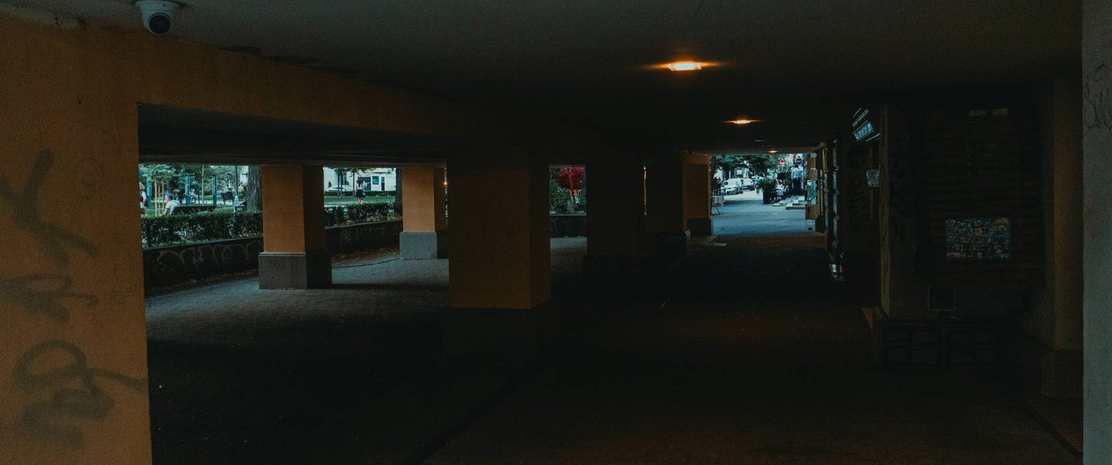 a dark hallway with graffiti on the walls