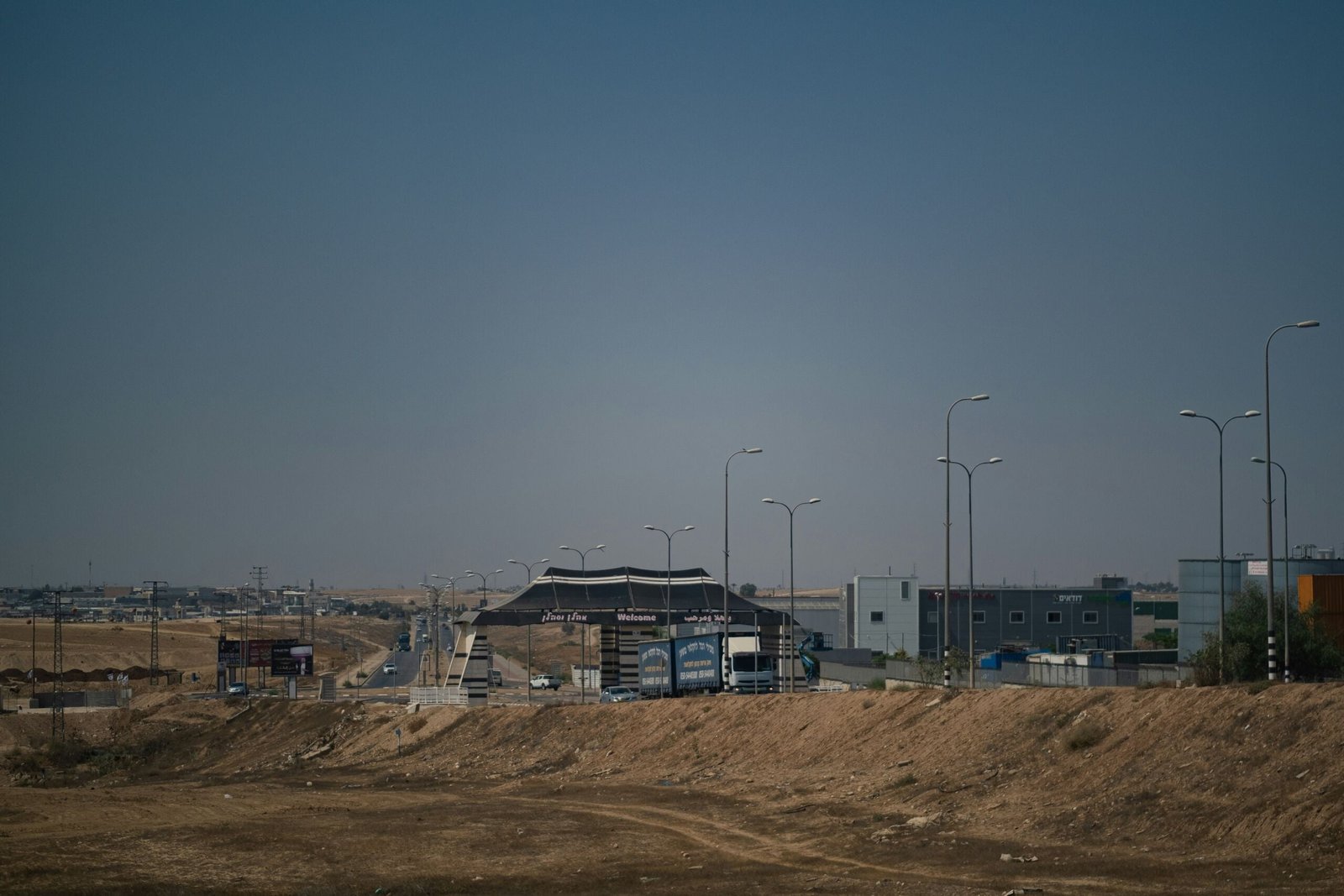 a dirt field with a building in the background