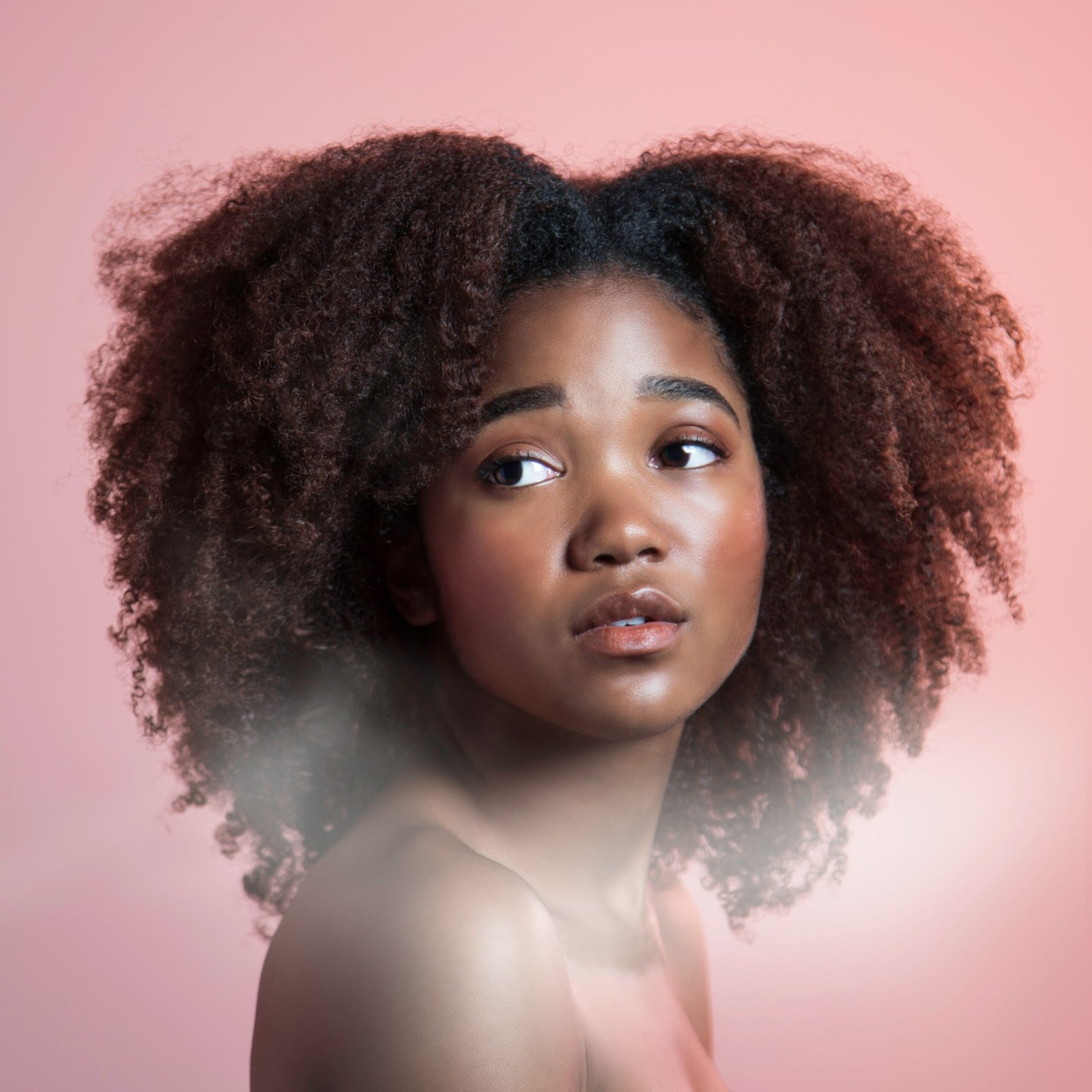 a woman with an afro is looking at the camera