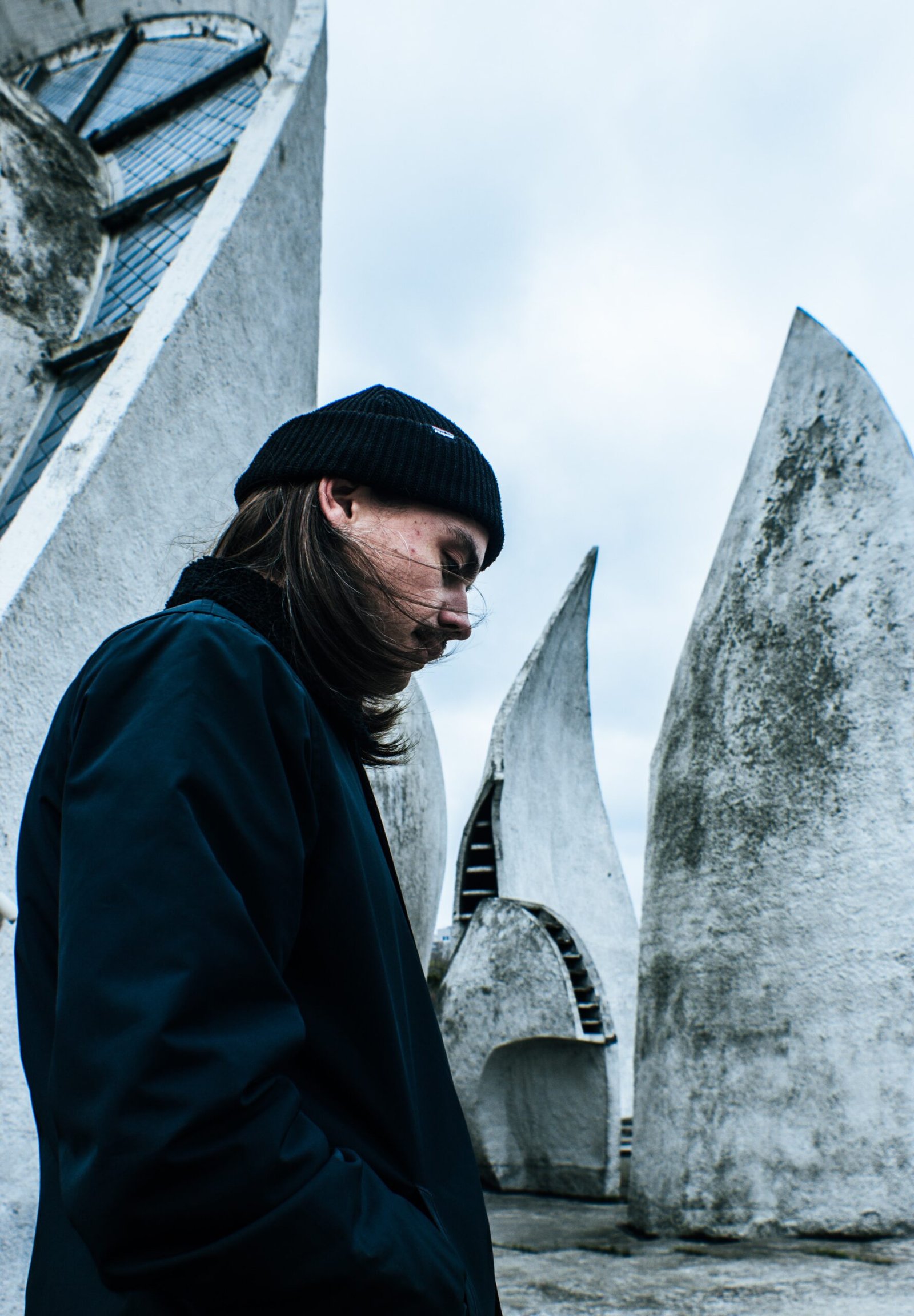 man standing and looking down near concrete wall